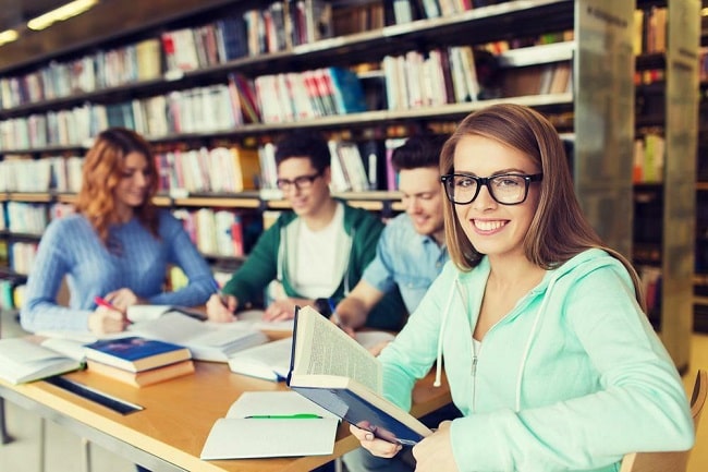 Students gathered around a table in a library