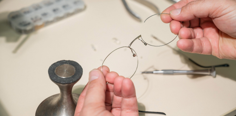 A person holding a pair of glasses, preparing to wear them